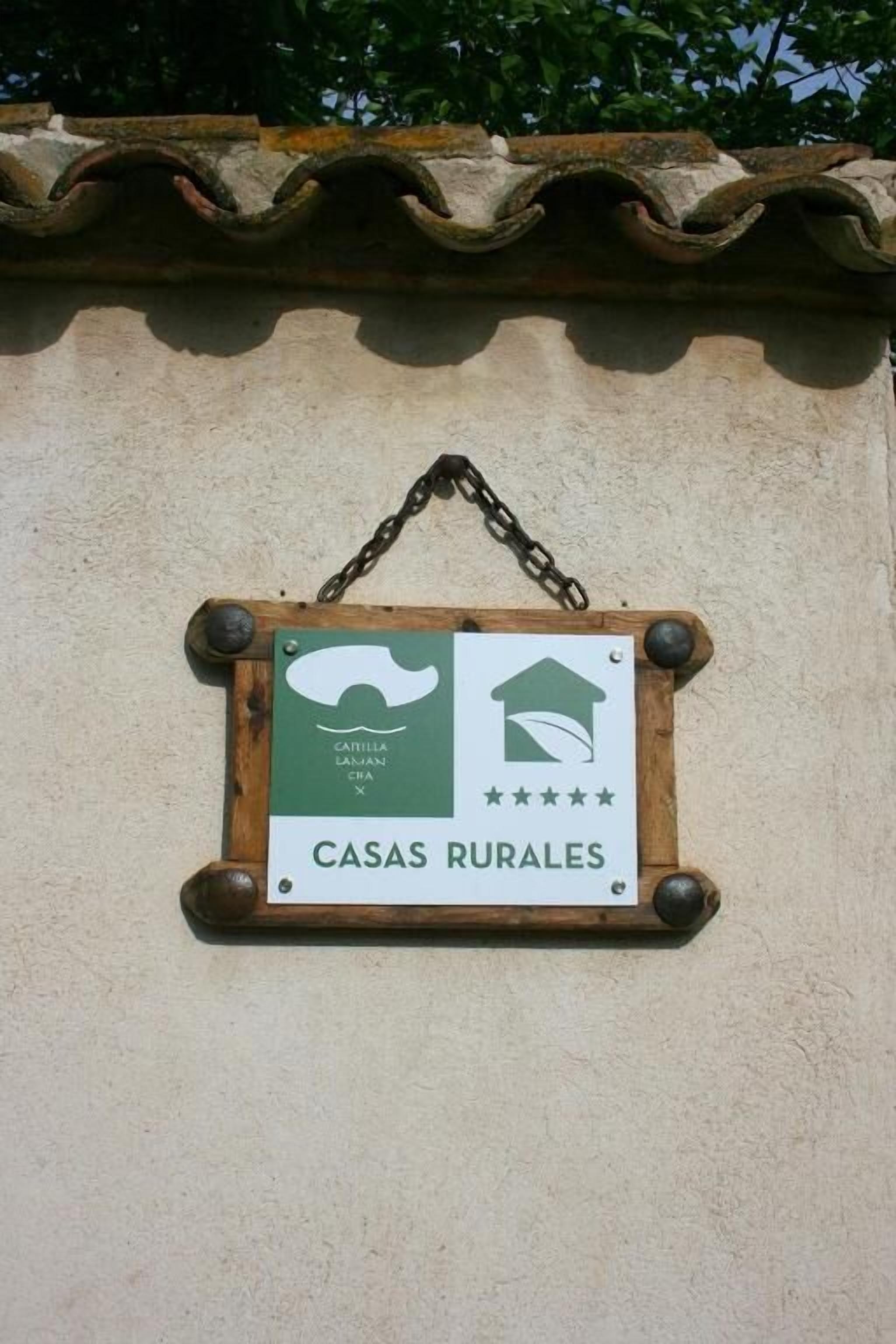 Un letrero que dice 'CASAS RURALES' con un diseño rústico, que incluye un icono de una casa y una valoración en estrellas.