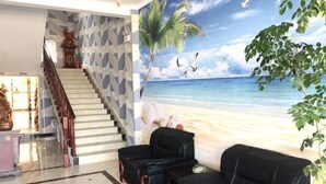 A lobby with a staircase, a beach mural, and seating areas. - Yilu Tongxing Chain Hotel (Suixi)