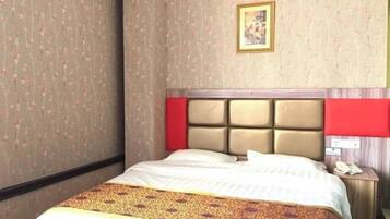 A hotel room with a bed, a nightstand, a telephone, and a framed picture on the wall.