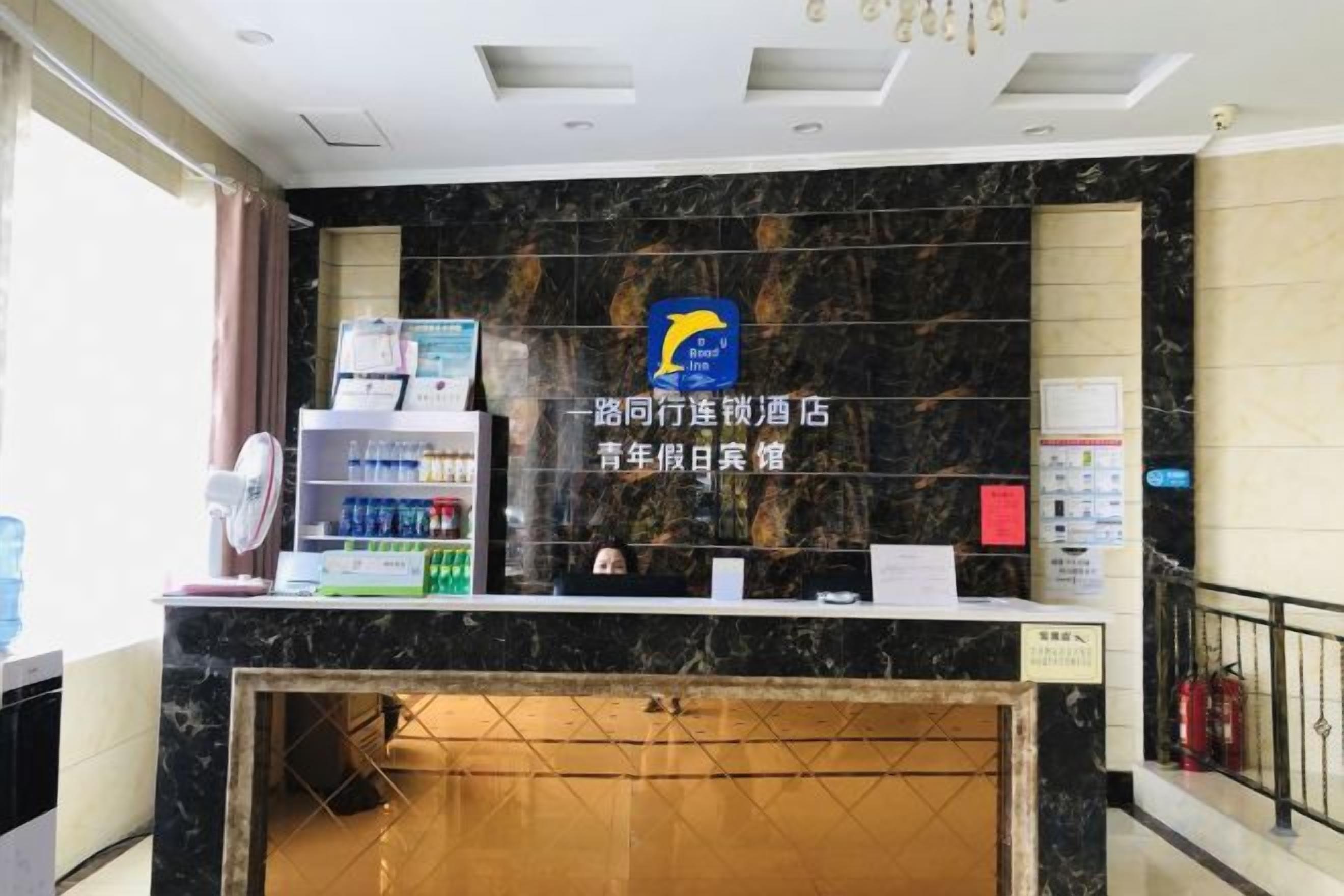 A reception desk with a marble counter, a blue logo, and a sign indicating a youth hotel.