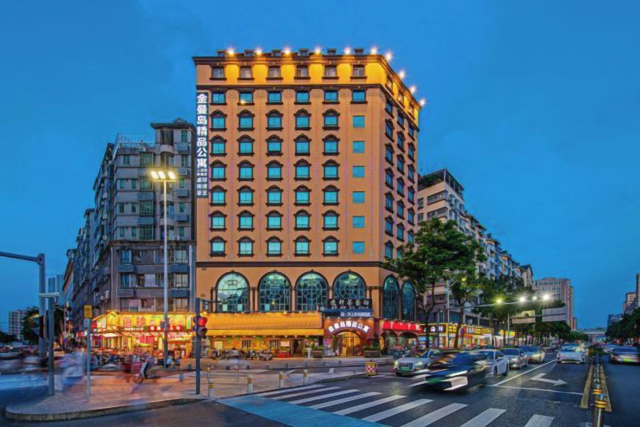 Un hôtel à plusieurs étages, doté d’une entrée imposante et d’une grande vitrine en arc de cercle.