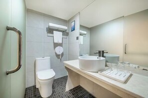 A modern bathroom with a toilet, bidet, and sink, equipped with a handrail and a mirror. - Jinman Island Hotel (Shenzhen Qinghu Subway Station Branch) (Shenzhen)