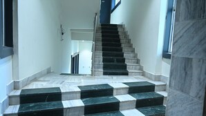 Una escalera con peldaños alternados en blanco y negro que suben a un piso superior.