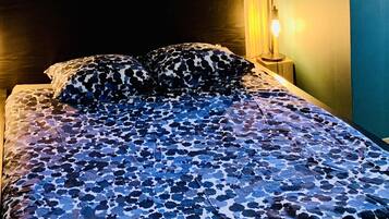 Une chambre avec un lit, deux oreillers et deux lampes de chevet.