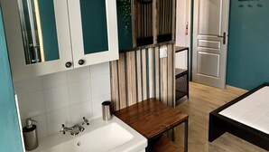 Een moderne badkamer met een wastafel, spiegel en houten opbergmeubel.