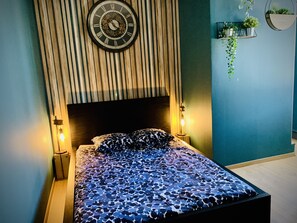 Une chambre à coucher avec un lit, une horloge et une table de chevet avec une lampe.