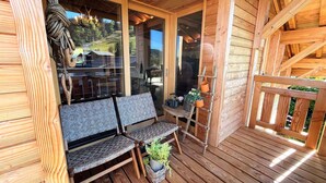 Eine Holzterrasse mit einer Bank und Topfpflanzen.