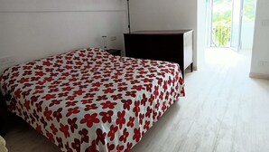 A bedroom with a bed, a desk, and a hanging light fixture. - Positano Little House. Sea view. White Dome.Terrace&WinePergola.15minToTheBeach (Positano)
