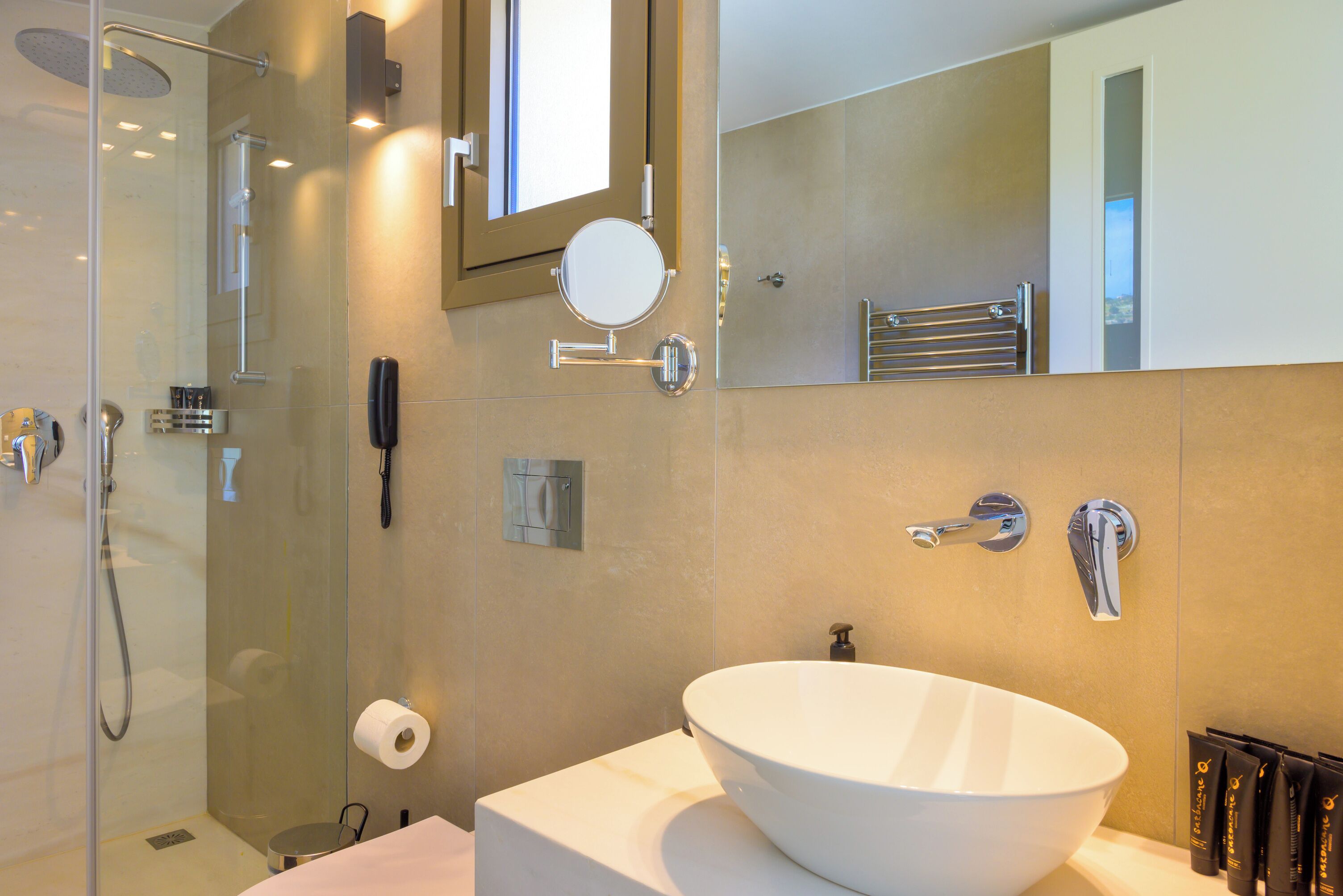 Ein modernes Badezimmer mit einem großen, weißen Waschbecken, einer Duschkabine und einem Spiegel über dem Waschbecken.