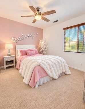 A bedroom with a bed, a nightstand, a lamp, a ceiling fan, and a window with blinds. - Kimberly's Private Palm Château Salt Pool & Hot Tub (Lake Elsinore)