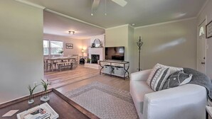 A living room with a white sofa, a coffee table, a fireplace, and a television. - Charming Retreat on 5 Acres w/ Deck & Grill! (Browns Summit)