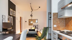 Un espace de vie compact comprenant un coin cuisine, un coin repas et un lit.
