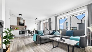 Un appartamento moderno con soggiorno, cucina e zona pranzo.