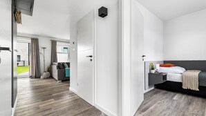 Una camera d'hotel moderna con un letto grande, una scrivania e vista sull'esterno.
