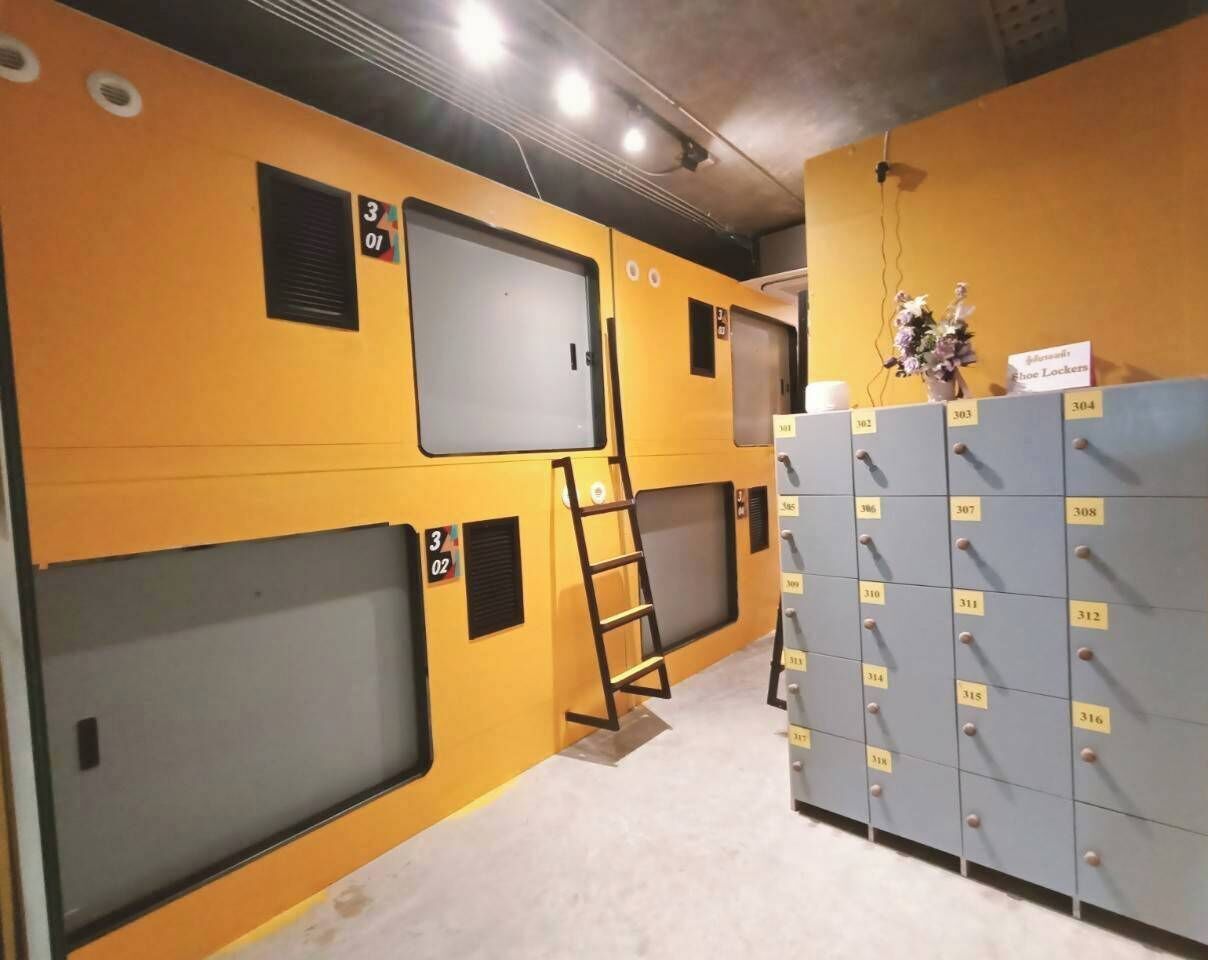 Un couloir avec des casiers, une échelle et un mur divisé en sections numérotées.