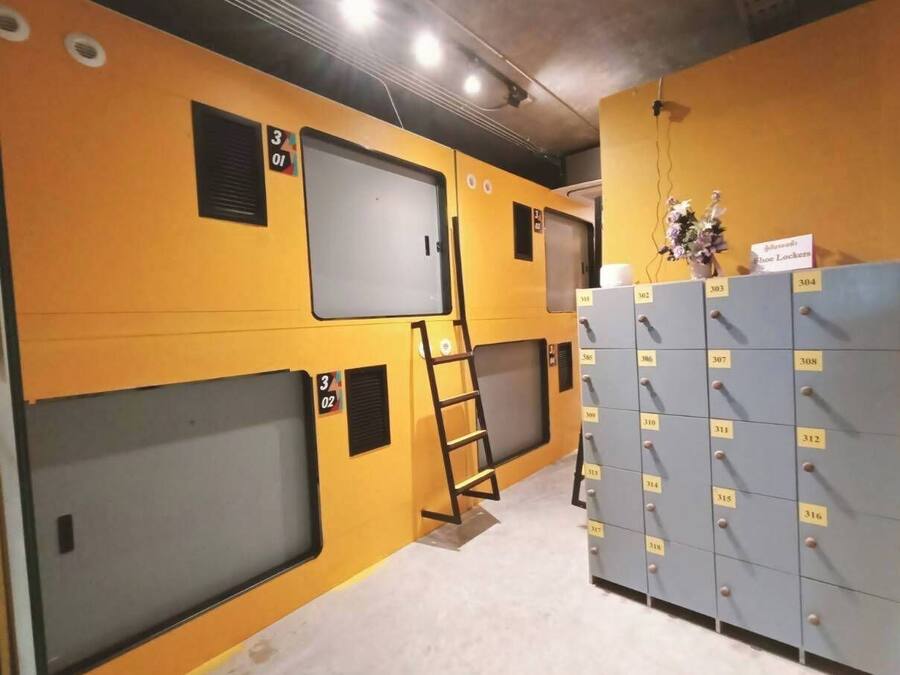 Un couloir avec des casiers, une échelle et un mur divisé en sections numérotées.