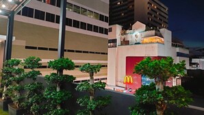 A modern building with a McDonald's sign, surrounded by well-maintained trees. - Icon Hotel Hatyai (Hat Yai)