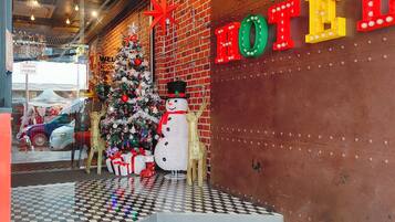 Entrada de hotel con un árbol de Navidad, un muñeco de nieve y una decoración de jirafa.