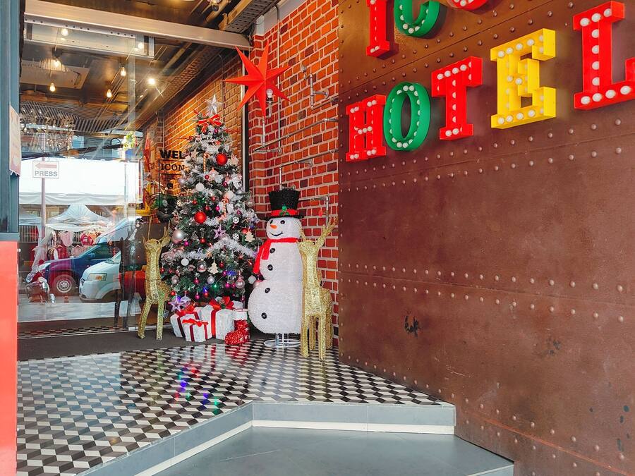 Entrada de hotel con un árbol de Navidad, un muñeco de nieve y una decoración de jirafa.