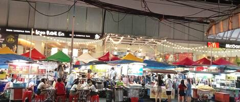 Un mercado interior animado con varios puestos y vendedores de comida.