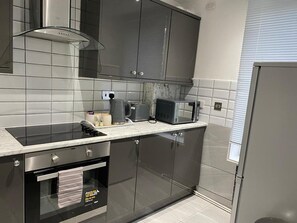 A modern kitchen with a built-in oven, microwave, and toaster. - Luxurious 2-bed Apartment in Woolwich, London (London)