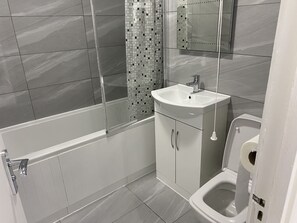 Ein modernes Badezimmer mit Dusche, Toilette und Waschbecken.