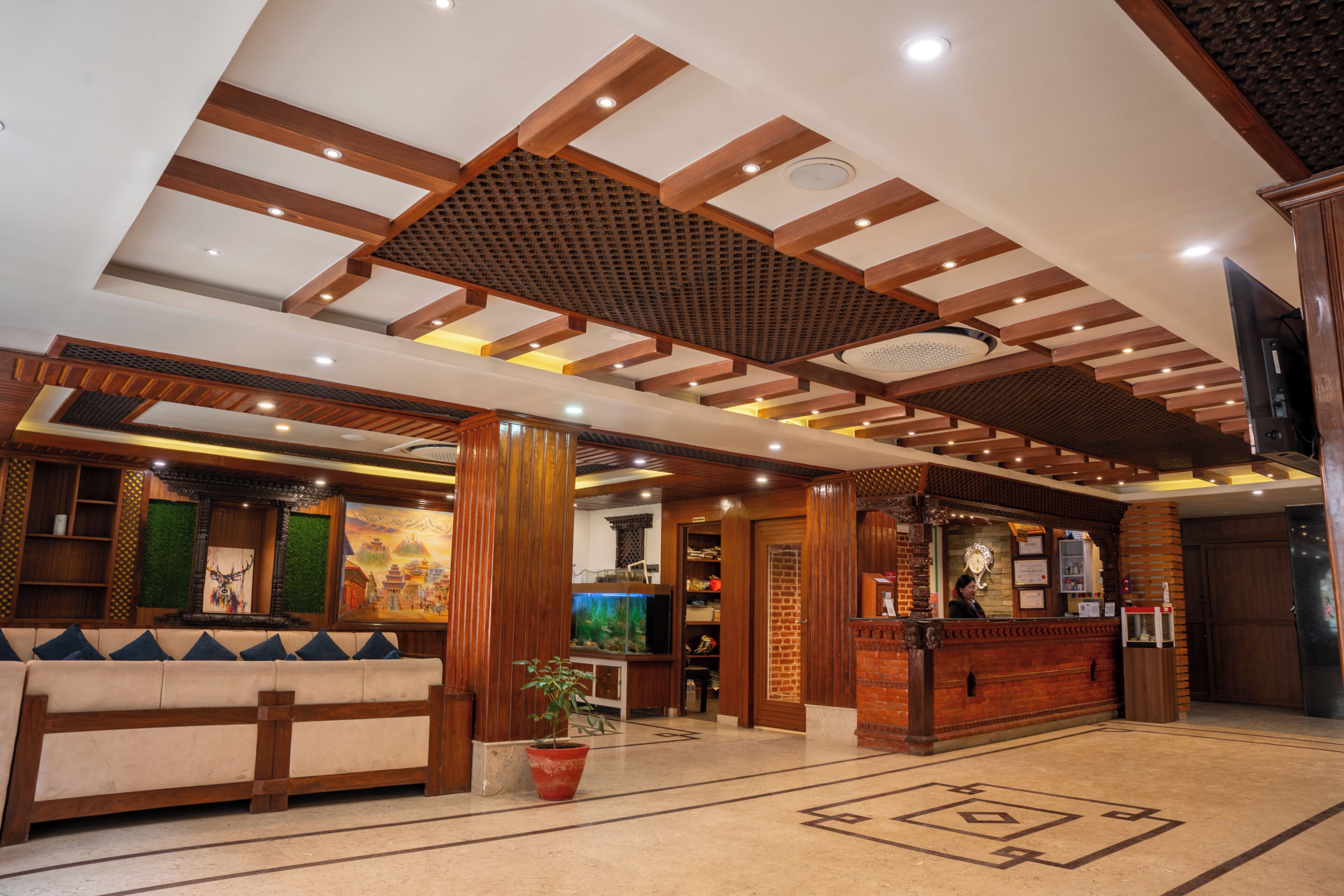 A lobby with a wooden reception desk, a seating area, and a large aquarium.
