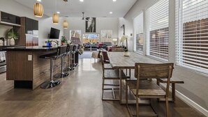 Une cuisine moderne avec un îlot central en bois, des tabourets de bar et des luminaires suspendus.