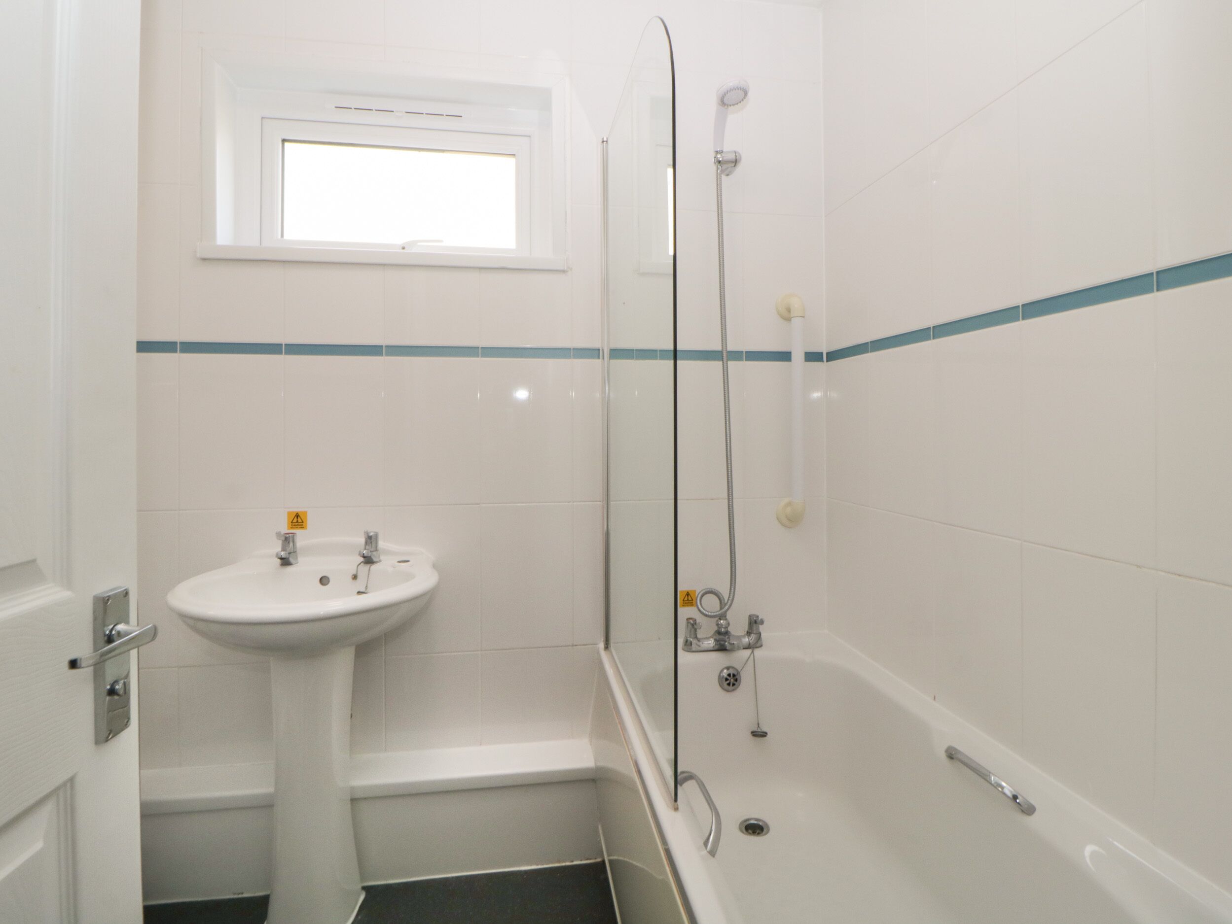 A bathroom with a sink, a window, and a bathtub.