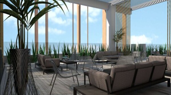 Un área lounge moderna al aire libre con asientos y vista al océano.