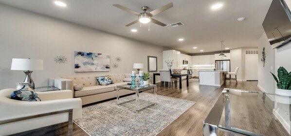 A modern living room with a sofa, coffee table, and dining area.