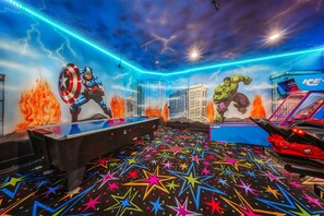 A room with a pool table, a dartboard, and a mural of superheroes. - Bohemian Chic Villa with Themed Bedrooms at Reunion (Kissimmee)