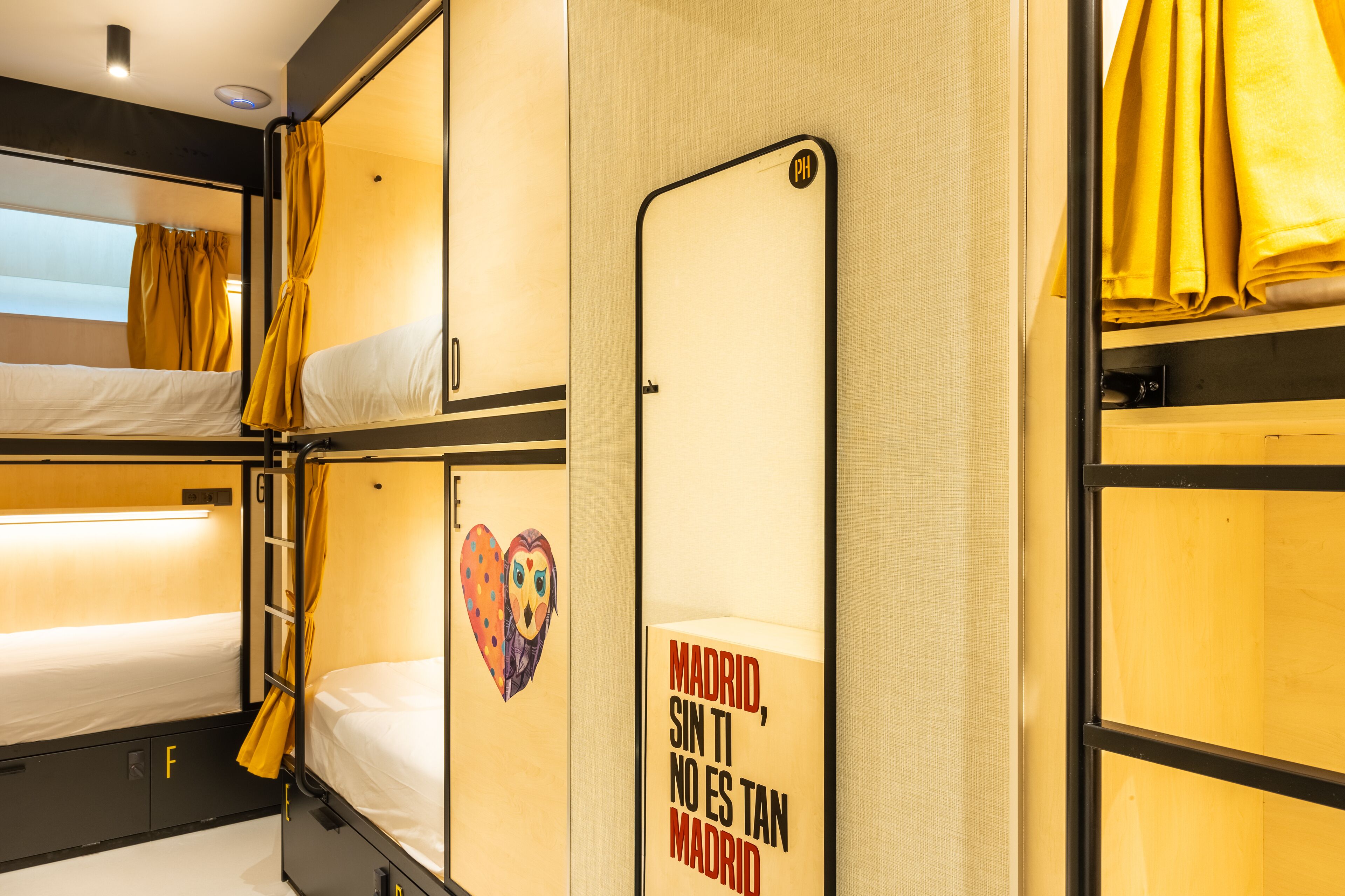 A bunk bed room with a mirror and a sign that reads "Madrid, sin ti no es tan Madrid".