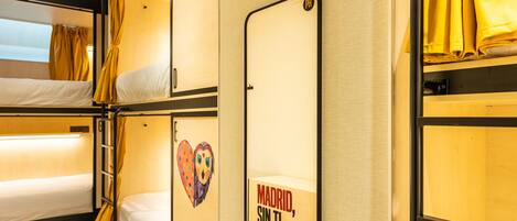 A bunk bed room with a mirror and a sign that reads "Madrid, sin ti no es tan Madrid".
