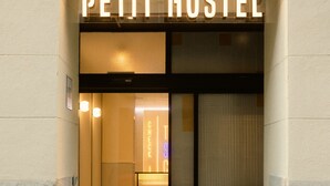 The entrance to a hotel named 'Petit Hostel' with a modern design, featuring a check-in counter and a visible interior space. - Petit Hostel Palacio Real (Madrid)