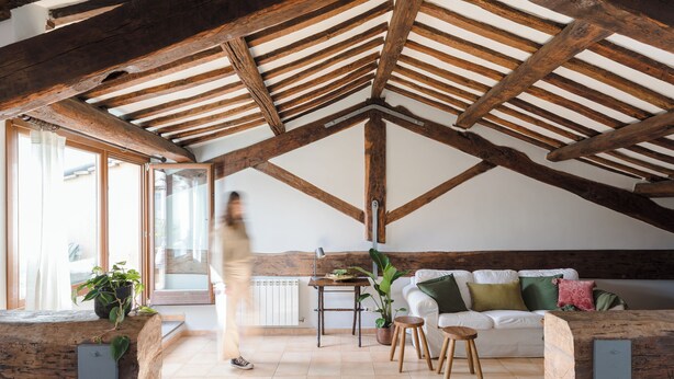 A spacious loft with exposed wooden beams, a white sofa, a dining table, and potted plants. - Penthouse in Trastevere with rooftop terrace🌱🌈 (Roma)
