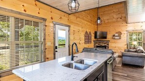 A modern kitchen with a granite countertop, stainless steel sink, and a built-in dishwasher. - Ooh LA LA, Private Indoor Pool, Arcade Game, Foosball, Free Attraction Tickets!! (Sevierville)