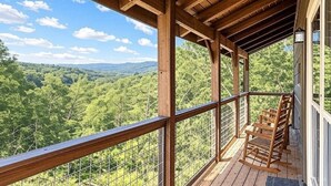 A wooden deck with a view of a forested landscape. - Ooh LA LA, Private Indoor Pool, Arcade Game, Foosball, Free Attraction Tickets!! (Sevierville)