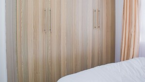 Un dormitorio con un armario grande, una cama y una cortina.