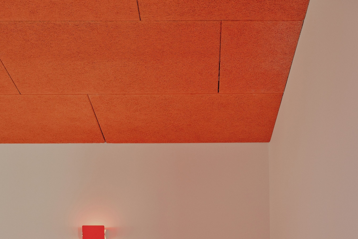 Un dormitorio con cama de madera, una silla de madera y una mesita de noche pequeña de madera.
