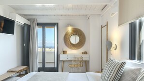 A modern bedroom with a bed, a desk, and a chair. - Escape View Villa (Santorini)