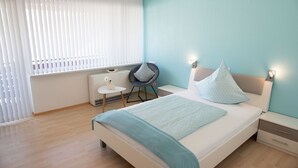 A modern bedroom with a bed, bedside tables, a chair, and a window with blinds. - Komfortable, neu Renovierte Few0 im Romantischen Weingut (Leiwen)