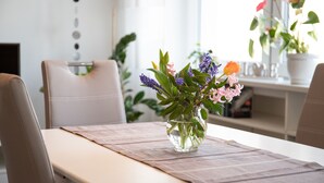 A dining table with a vase of flowers, chairs, and a bookshelf in the background. - Komfortable, neu Renovierte Few0 im Romantischen Weingut (Leiwen)