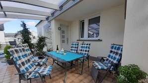 An outdoor patio with a table and four chairs, surrounded by potted plants. - Komfortable, neu Renovierte Few0 im Romantischen Weingut (Leiwen)