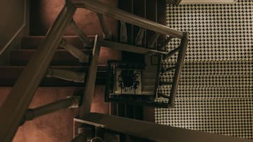A staircase with a houndstooth patterned floor and a metal handrail.