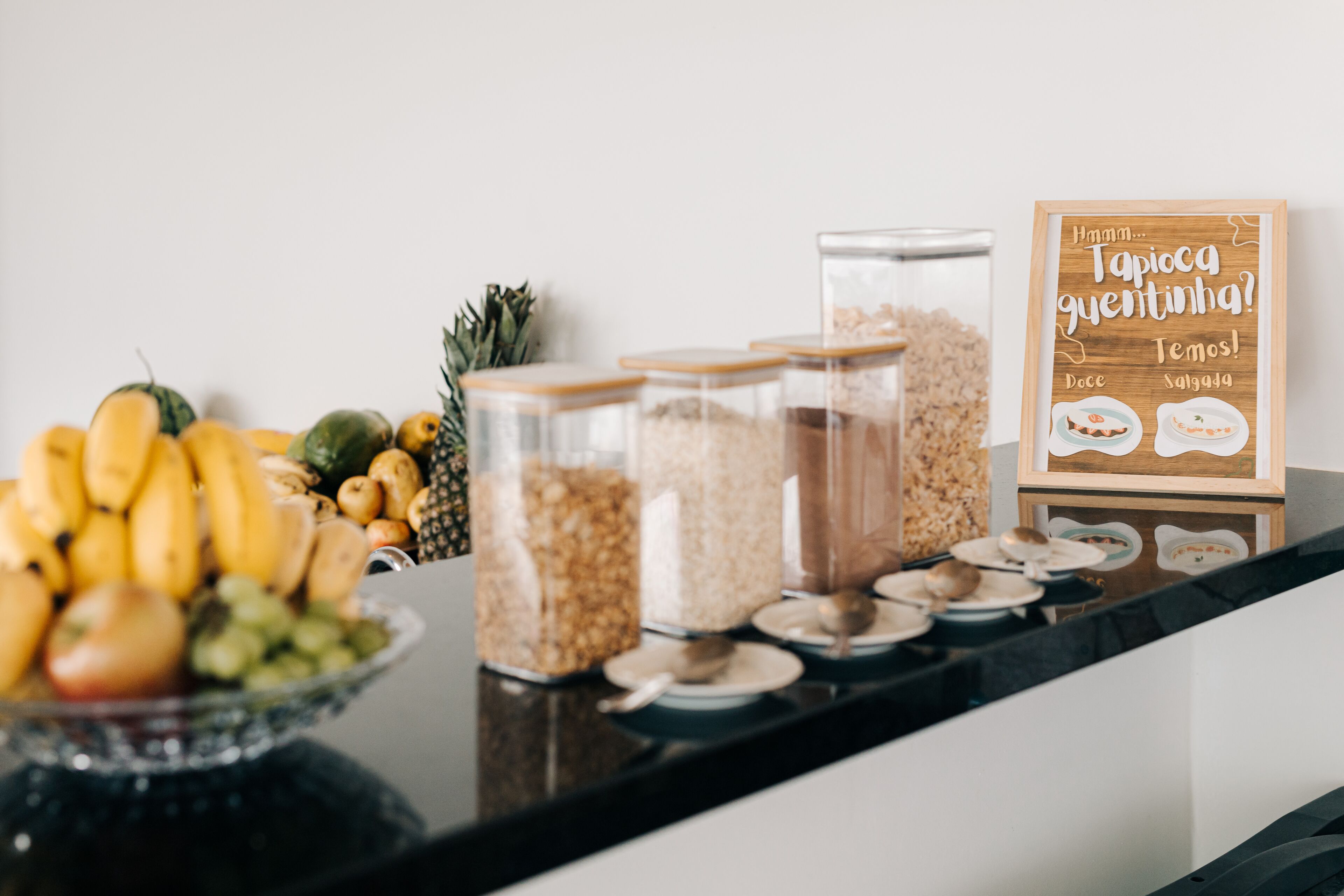 Disposição de buffet com diversos alimentos e uma placa.
