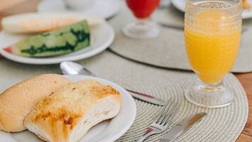 A breakfast setting with a plate of food, a glass of orange juice, and a cup of coffee on a wooden table.