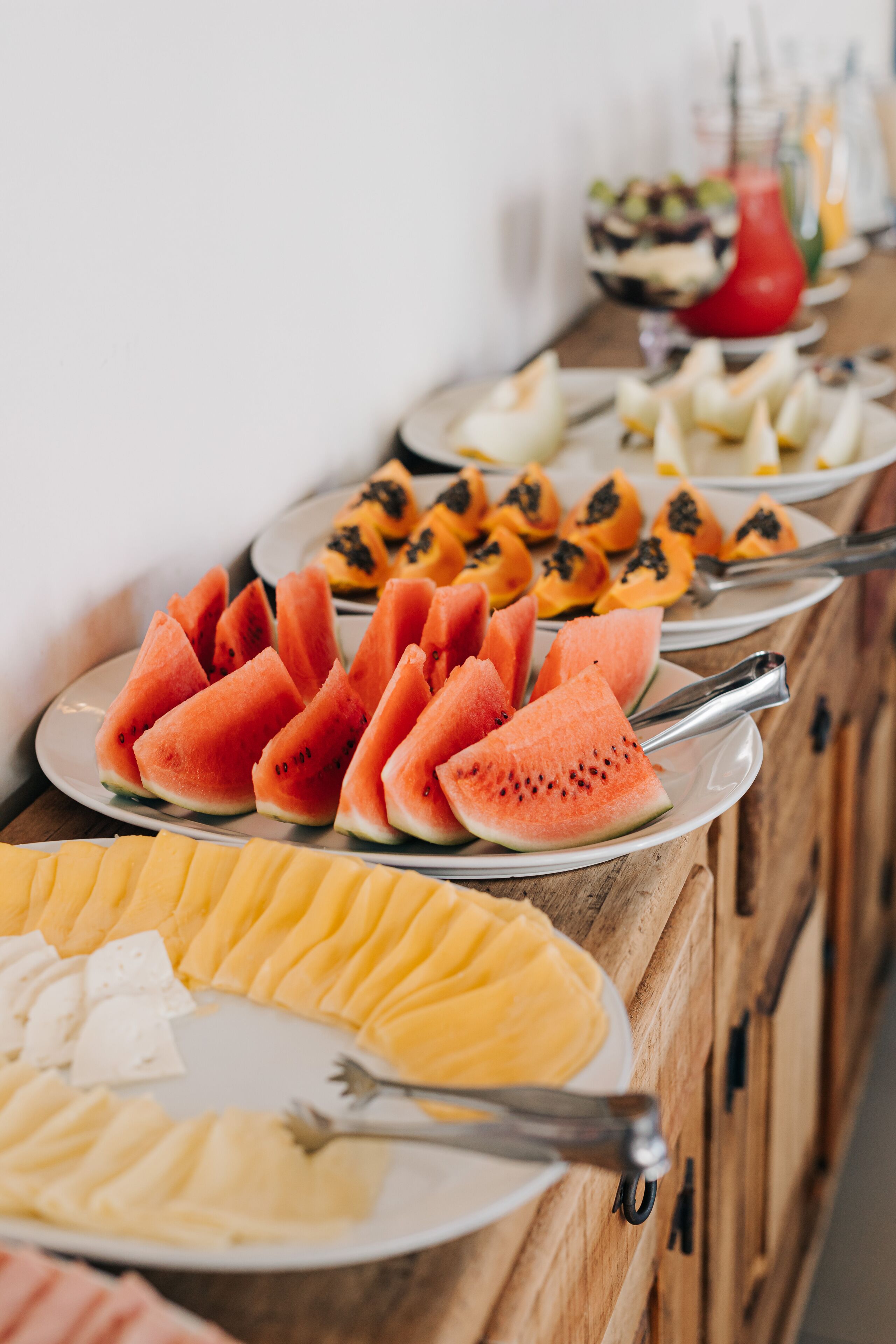 Ein Buffet mit verschiedenen Früchten und einer roten Getränkespender.