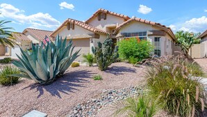 A house with a garage, surrounded by desert plants and a clear sky. - Gated! 3/2 Pool, Bbq, Fire-Table! License #2034087 (Scottsdale)
