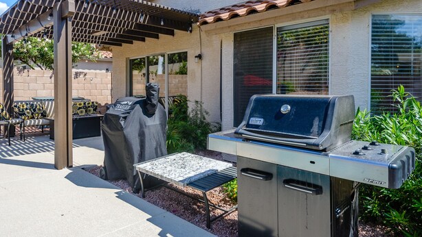 An outdoor patio with a grill, covered seating, and a pergola. - Gated! 3/2 Pool, Bbq, Fire-Table! License #2034087 (Scottsdale)